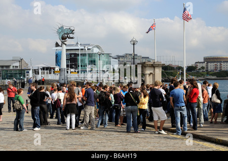 Giovani gruppi turistici a raccogliere il Mayflower Steps in Plymouth Devon Foto Stock