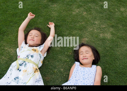 Due ragazze di dormire su erba Foto Stock