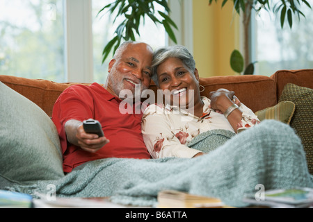 Senior coppia africana di guardare la televisione Foto Stock