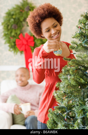 Razza mista donna immissione ornamento su albero di Natale Foto Stock