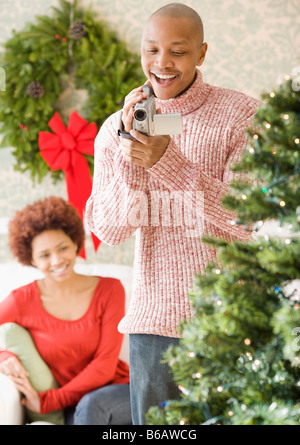L'uomo africano utilizzando la telecamera video film per albero di Natale Foto Stock