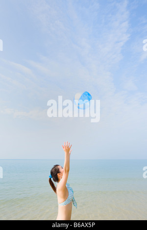 Giovane donna che gioca con la palla spiaggia Foto Stock