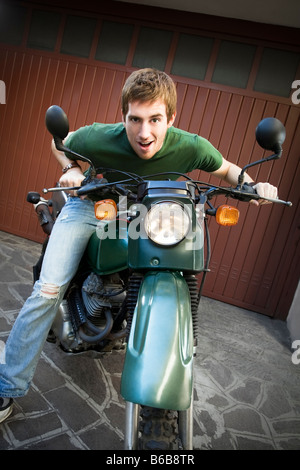 Ritratto di giovane uomo seduto sulla moto Foto Stock
