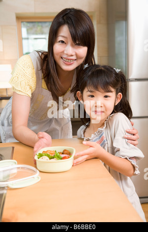 Madre e figlia che mostra lunchbox Foto Stock