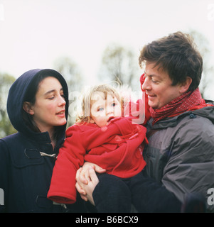 Una coppia di Londra con un giovane bambino indossando abiti invernali in un parco a Walthamstow, Londra, Inghilterra KATHY DEWITT Foto Stock