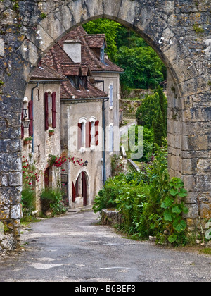 Visualizzazione attraverso l'arcata in pietra di una via del borgo rurale in Francia Foto Stock