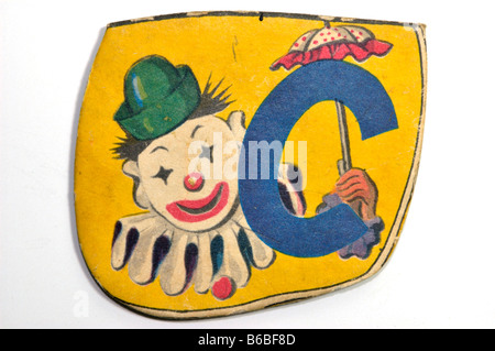 Vintage lettera alfabeto pezzo di puzzle per i bambini con la lettera C e il carattere di un clown stampati su di essa Foto Stock