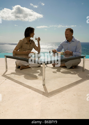 Giovane avente il cibo in tavola Foto Stock