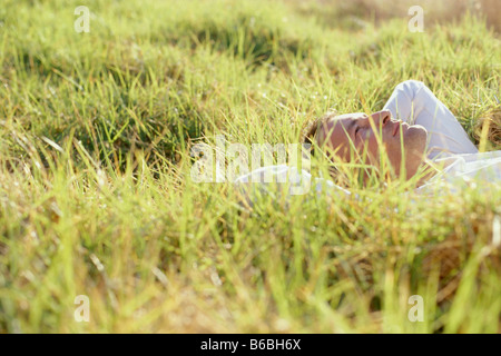 Profilo laterale dell uomo disteso sull'erba Foto Stock