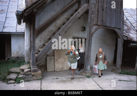 Le persone che entrano nel fortificato chiesa sassone in Szekelyderz dariju villaggio in Transilvania Romania Foto Stock