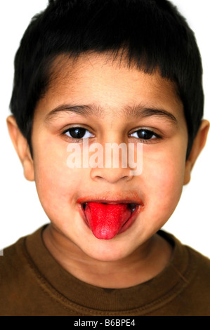 Un bel ragazzo che mostra la sua lingua dopo aver mangiato una caramella Foto Stock