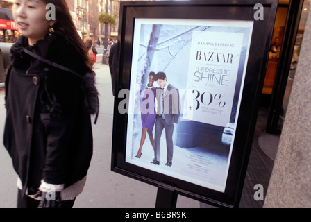 Gli amanti dello shopping pass segni di vendita nei negozi di Herald Square Shopping District di New York Foto Stock