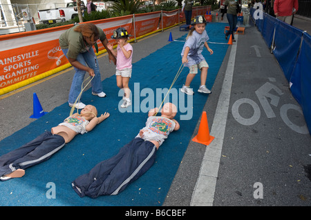 I ragazzi al percorso ad ostacoli con bambino fire rescue manichini in Downtown Arts Festival Gainesville Florida Foto Stock