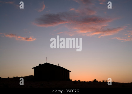 Africa Namibia Impostazione Kolmanskop sole illumina le nuvole dietro decadendo edificio nella città fantasma di diamante abbandonate città mineraria Foto Stock