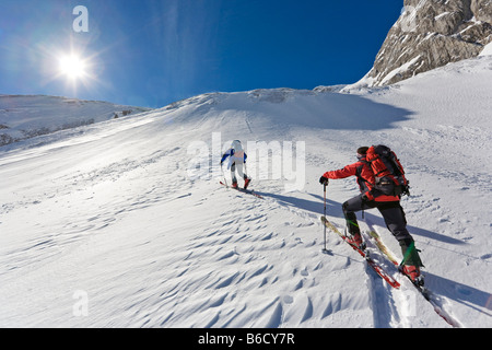 Vista posteriore di due sciatori a piedi con gli sci sulla montagna snowcovered, Knallstein, Tennengebirge, Tennengau, Salisburgo, Austria Foto Stock