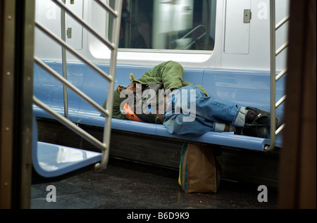 Senzatetto uomo dorme in NYC Metropolitana (per solo uso editoriale) Foto Stock