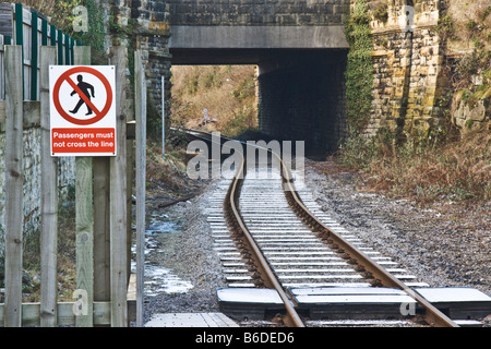 Linea ferroviaria con cartelli di avvertimento per i pedoni di non avventurarsi sulla linea. Foto Stock