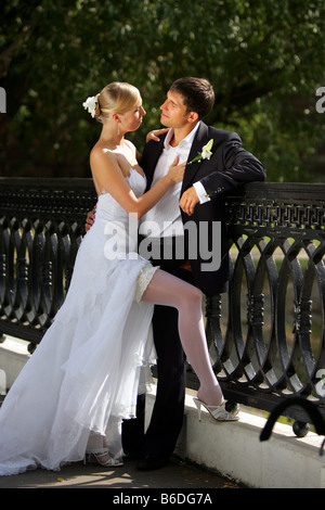 Sposa giovane in amore si fermò sul ponte in campagna sorridente Foto Stock