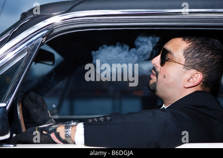 Un uomo fuma in suo automobile Foto Stock