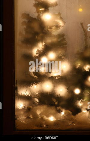 Le decorazioni di Natale in una vetrina di un negozio che si è appannata dal freddo esterno Foto Stock