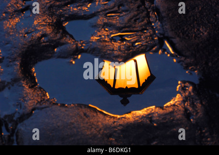 La riflessione di lampione in una pozza dopo una doccia a pioggia, Ciqikou antica città di Chongqing Cina Foto Stock