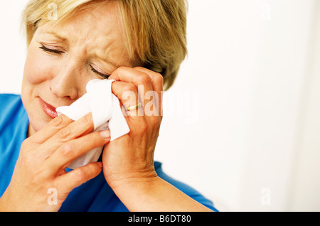 Triste donna, donna di mezza età a piangere e asciugare le lacrime dai suoi occhi. Foto Stock