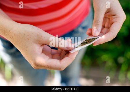 Uso di cannabis. Ragazza adolescente preparare una sigaretta fatta con tabacco e cannabis. Foto Stock