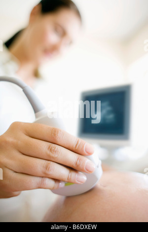 Donna incinta facendo a ultrasuoni clinica Foto Stock