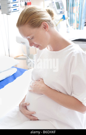 Donna incinta in un reparto di maternità tenendo il suo ventre gonfio. Foto Stock