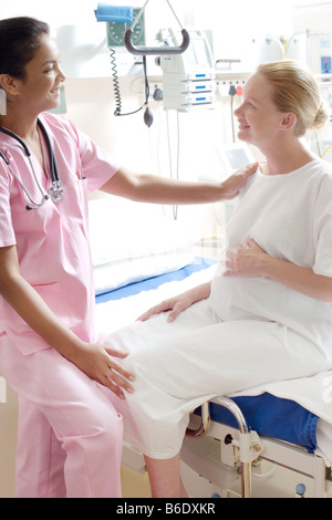 Gravidanza check-up. Ostetrico a parlare con una donna in stato di gravidanza su un reparto di maternità. Foto Stock
