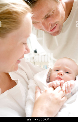 I genitori e il bambino neonato. Il padre e la madre in un reparto di maternità mantenendo le loro neonato. Foto Stock