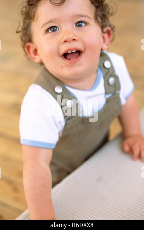 Baby boy. 9-mese-vecchio baby boy in piedi con le mani per il supporto. Foto Stock