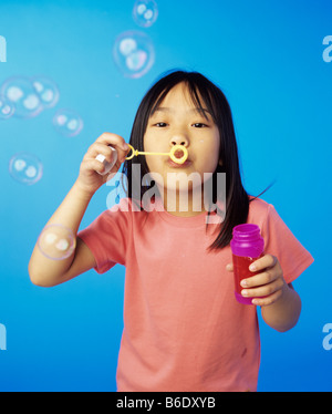 Soffiare bolle.6-anno-vecchia ragazza soffia bolle di sapone da una bacchetta magica. Foto Stock