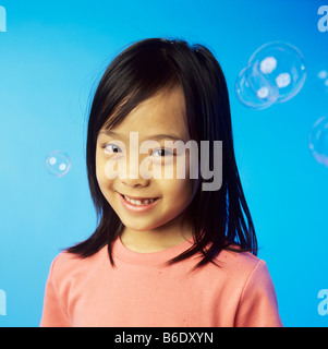 Bolle. 6 anno vecchia ragazza circondato da bolle di sapone. Foto Stock