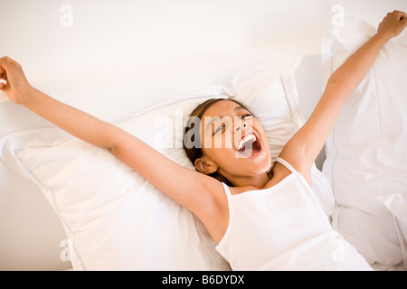 Happy girl stretching nel letto. Foto Stock
