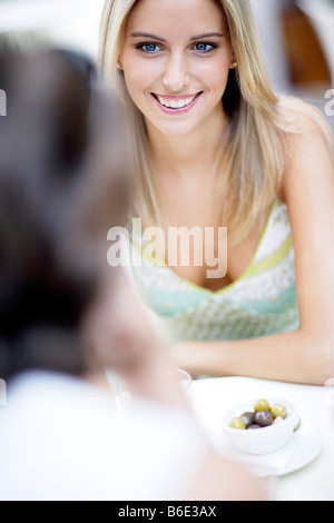 Giovani amici seduti a tavola Foto Stock