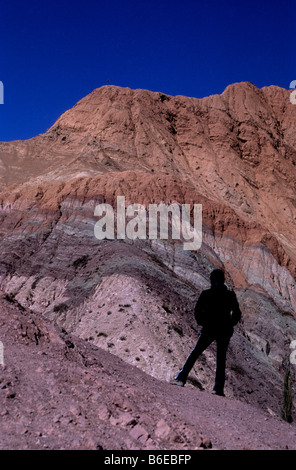 Turisti che guardano i colorati strati rocciosi e le formazioni della collina dei sette colori, Purmamarca, Quebrada de Humahuaca, Provincia Jujuy, Argentina Foto Stock