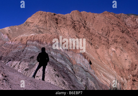 Turisti che guardano i colorati strati rocciosi e le formazioni della collina dei sette colori, Purmamarca, Quebrada de Humahuaca, Provincia Jujuy, Argentina Foto Stock