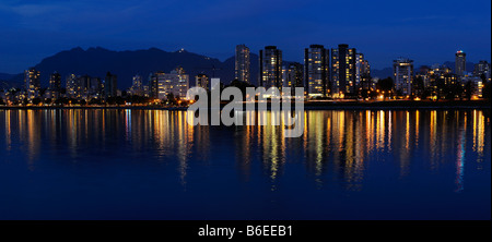 Panorama di West End skyline di Vancouver luci della città al tramonto riflesso in English Bay con Grouse Mountain della Columbia britannica in Canada Foto Stock