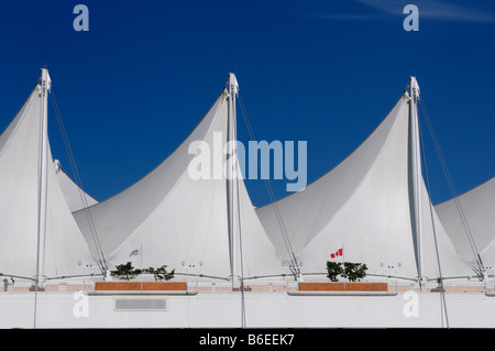 Abstract white Canada Place vele in Vancouver contro un cielo blu con la bandiera canadese della Columbia britannica in Canada Foto Stock