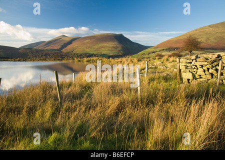 Tewet Tarn nella luce della sera guardando verso Skiddaw e Blencathra Lake District Cumbria Regno Unito Foto Stock