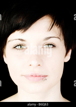 La faccina sorridente di un oscuro dai capelli donna con un labbro trafitto Foto Stock