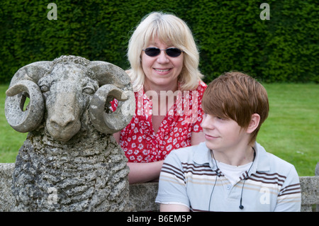 Ragazzo adolescente con donna di mezza età sedeva accanto a una pietra di ram Nottinghamshire England Regno Unito Foto Stock