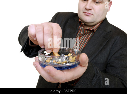 L'uomo urto fuori una sigaretta in un ash-tray Foto Stock