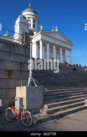 Red bike e gente seduta sui gradini di fronte la Cattedrale di Helsinki Helsinki Finlandia Foto Stock