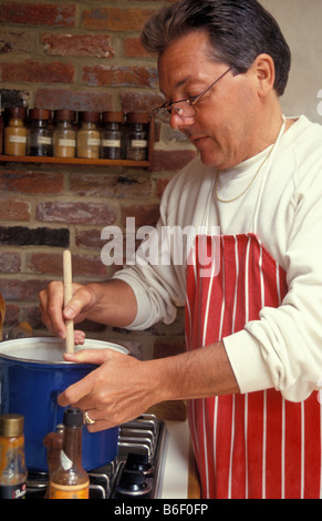 Uomo di mezza età per la cottura in cucina di paese Foto Stock