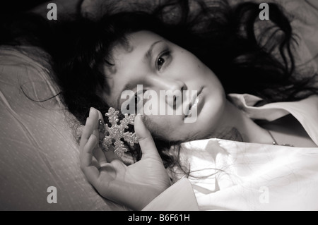 Una donna con il simbolo del fiocco di neve in mano Foto Stock