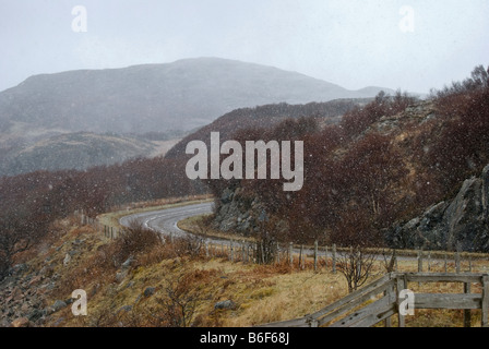 Neve che cade lungo la strada costiera A832 vicino a Gruinard Bay, a Wester Ross, Highlands scozzesi Foto Stock