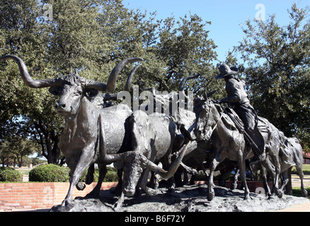 Statua di bronzo di Texas Longhorn capi di bestiame si imbrancò da un cowboy a cavallo si trova nei pressi del Forth Worth Stockyards Foto Stock