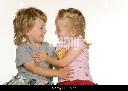 Ragazzo e una ragazza, tre e due anni, avvolgente e sorridente ad ogni altro Foto Stock